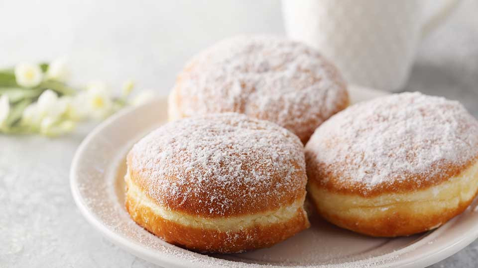 auf diesem Bild befinden sich 3 mit Zucker bestreute Krapfen;